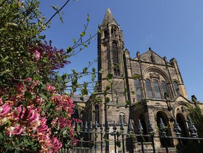 Une église historique dotée d’un haut clocher et de fenêtres en arc de cercle.