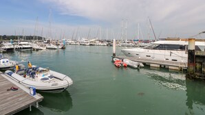 A marina with various boats docked, wooden walkways, and a clear sky. - Hurst View (Freshwater)