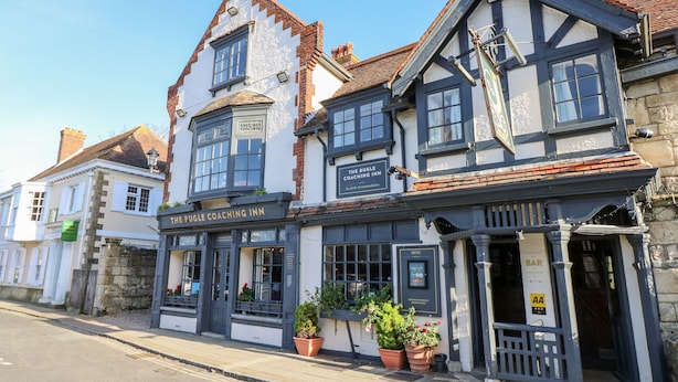 A traditional building with a sign for "The Puggle Coaching Inn" and a "Bar" entrance. - Hurst View (Freshwater)