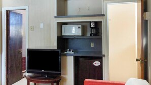 A compact room with a television, a microwave, and a coffee maker on a shelf. - OYO Hotel Wilkes-Barre East (Wilkes-Barre)