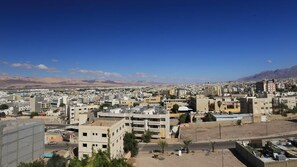 Un paysage urbain présentant une variété de bâtiments, notamment des immeubles résidentiels et des édifices commerciaux, sous un ciel dégagé.