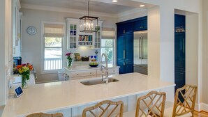 A modern kitchen with a large island, white cabinetry, and blue accents. - Great house with dock on Lake Murray SC.  Excellent for families, fishing, fun (Prosperity)