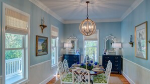 A dining room with a round table, white chairs, and a chandelier. - Great house with dock on Lake Murray SC.  Excellent for families, fishing, fun (Prosperity)