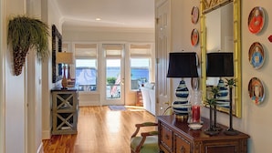 A spacious room with hardwood flooring, a large rug, a green armchair, a wooden dresser, and a mirror on the wall. - Great house with dock on Lake Murray SC.  Excellent for families, fishing, fun (Prosperity)