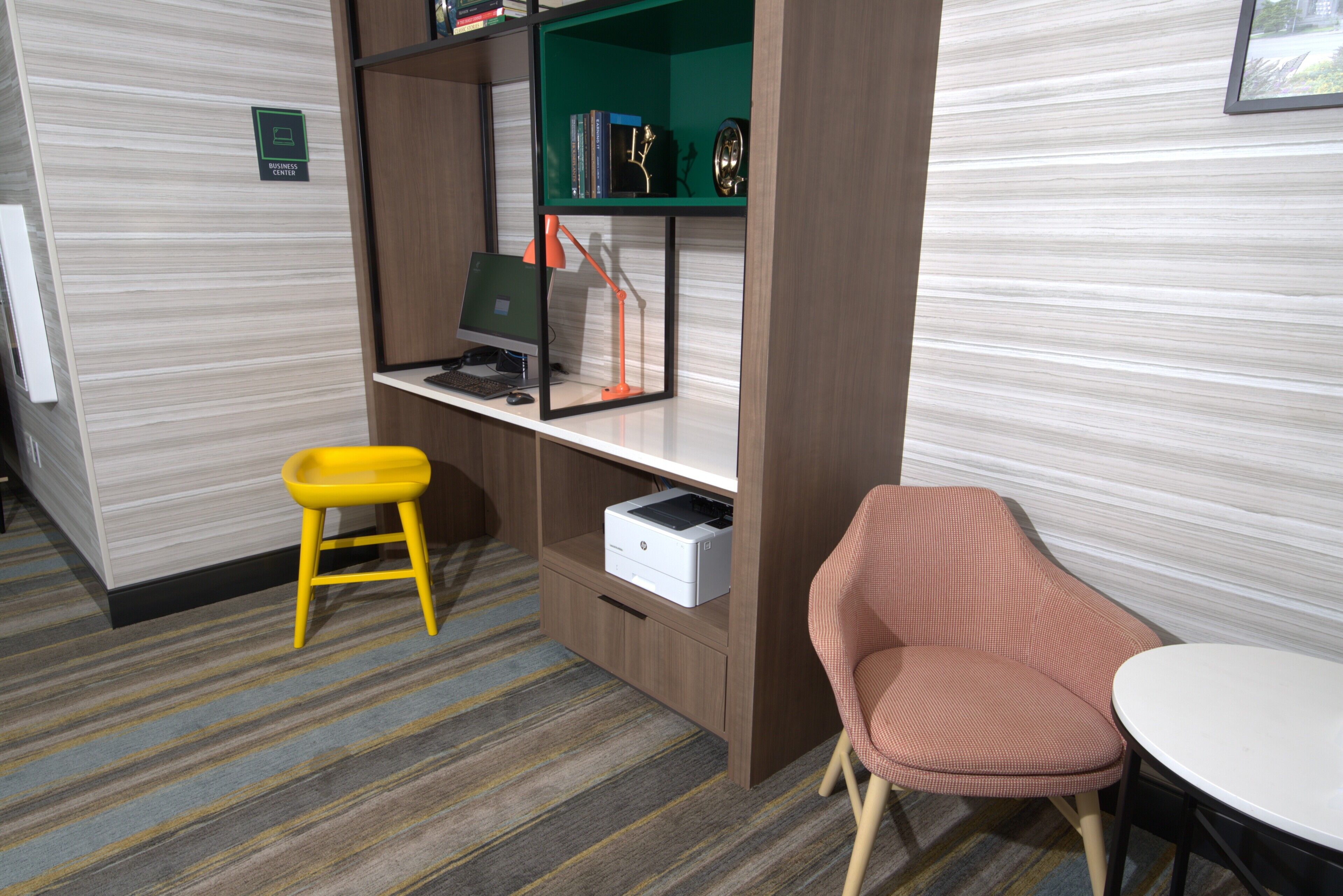 A room with a desk, chair, bookshelf, and a printer.