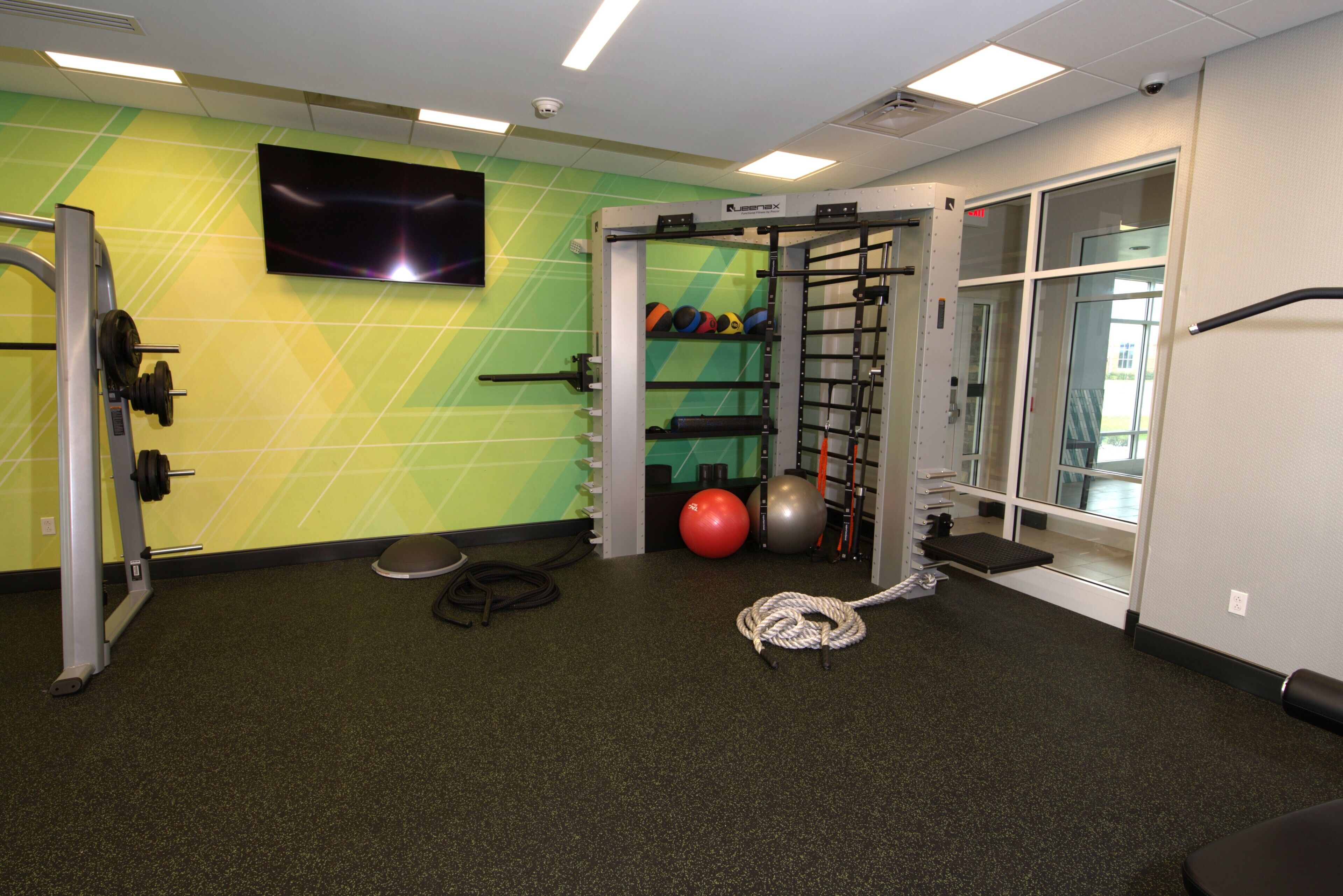 A gym with a pull-up bar, weight bench, and exercise balls.
