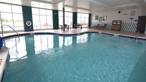 An indoor swimming pool with clear water, a pool ladder, and lounge chairs. - Holiday Inn Hotel & Suites Hopkinsville - Convention Ctr by IHG (Hopkinsville)