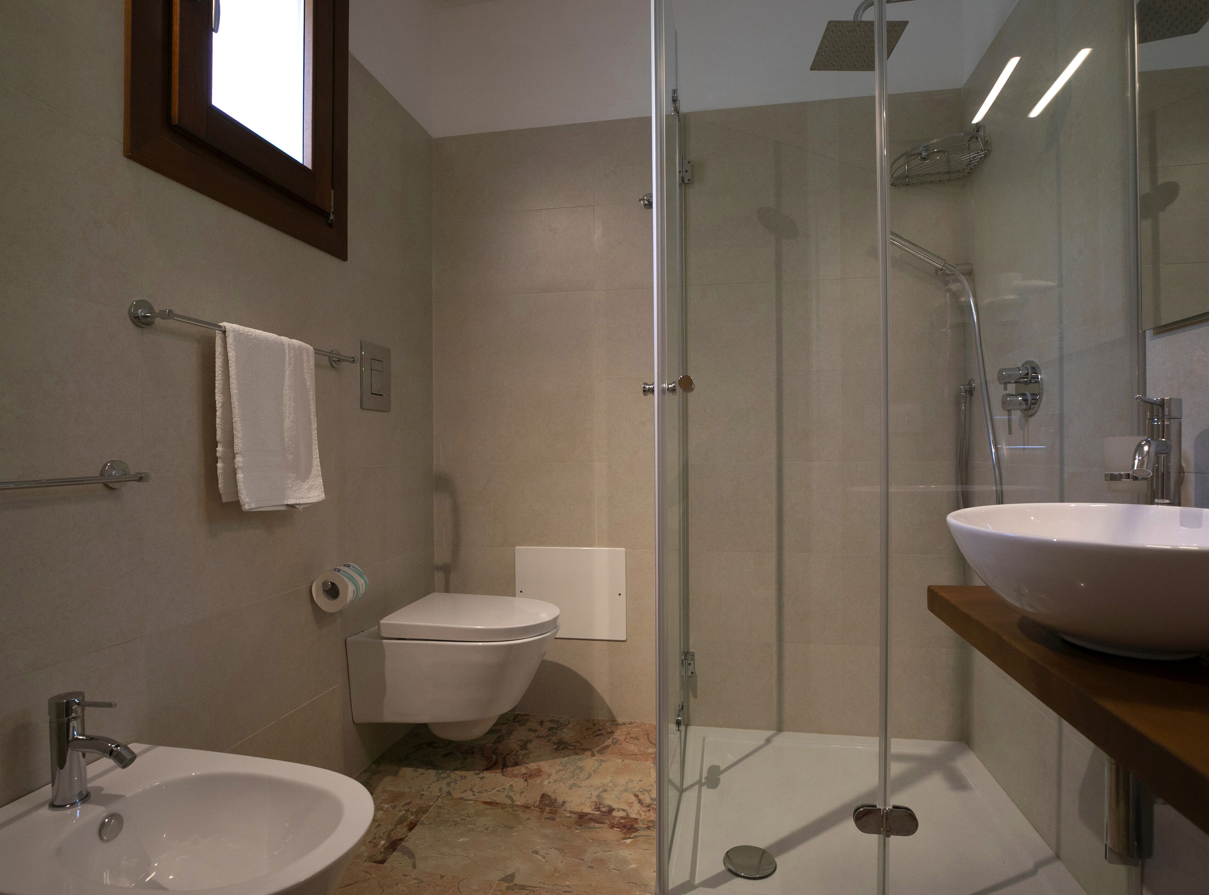 Une salle de bain moderne avec une douche à parois de verre, un lavabo blanc et des toilettes.