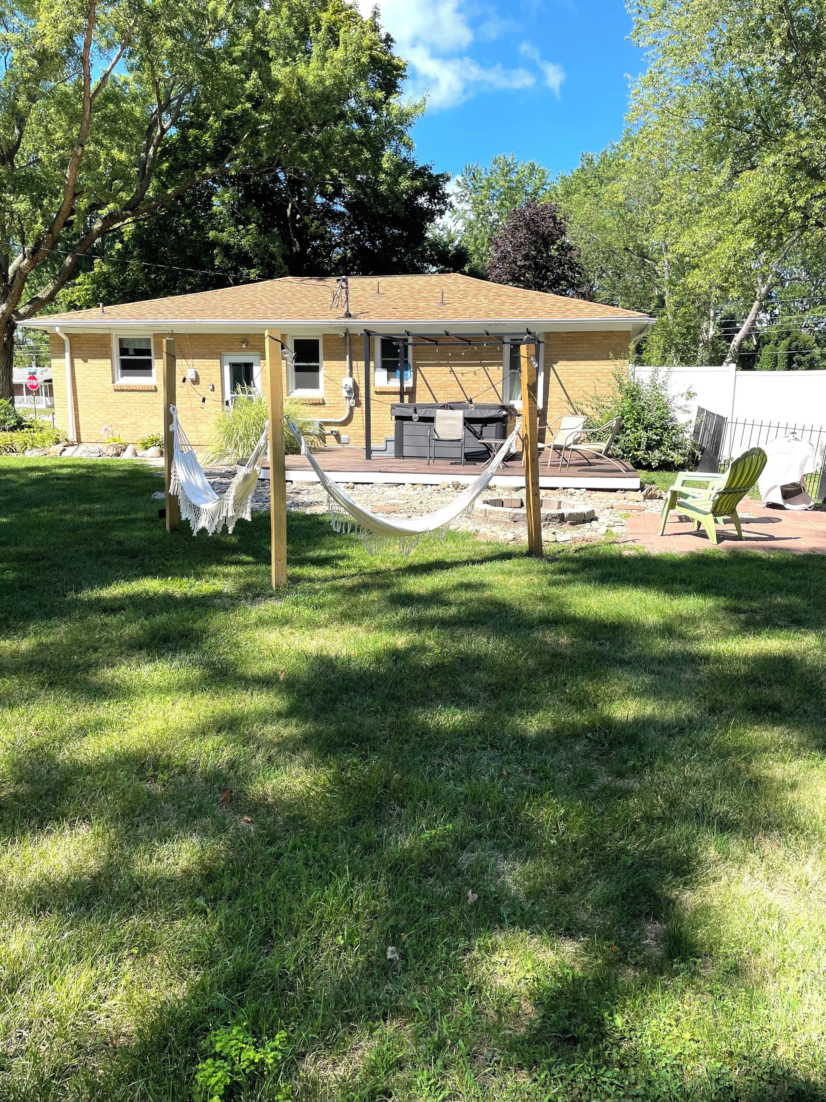 A house with a covered patio, a hammock, and outdoor seating.