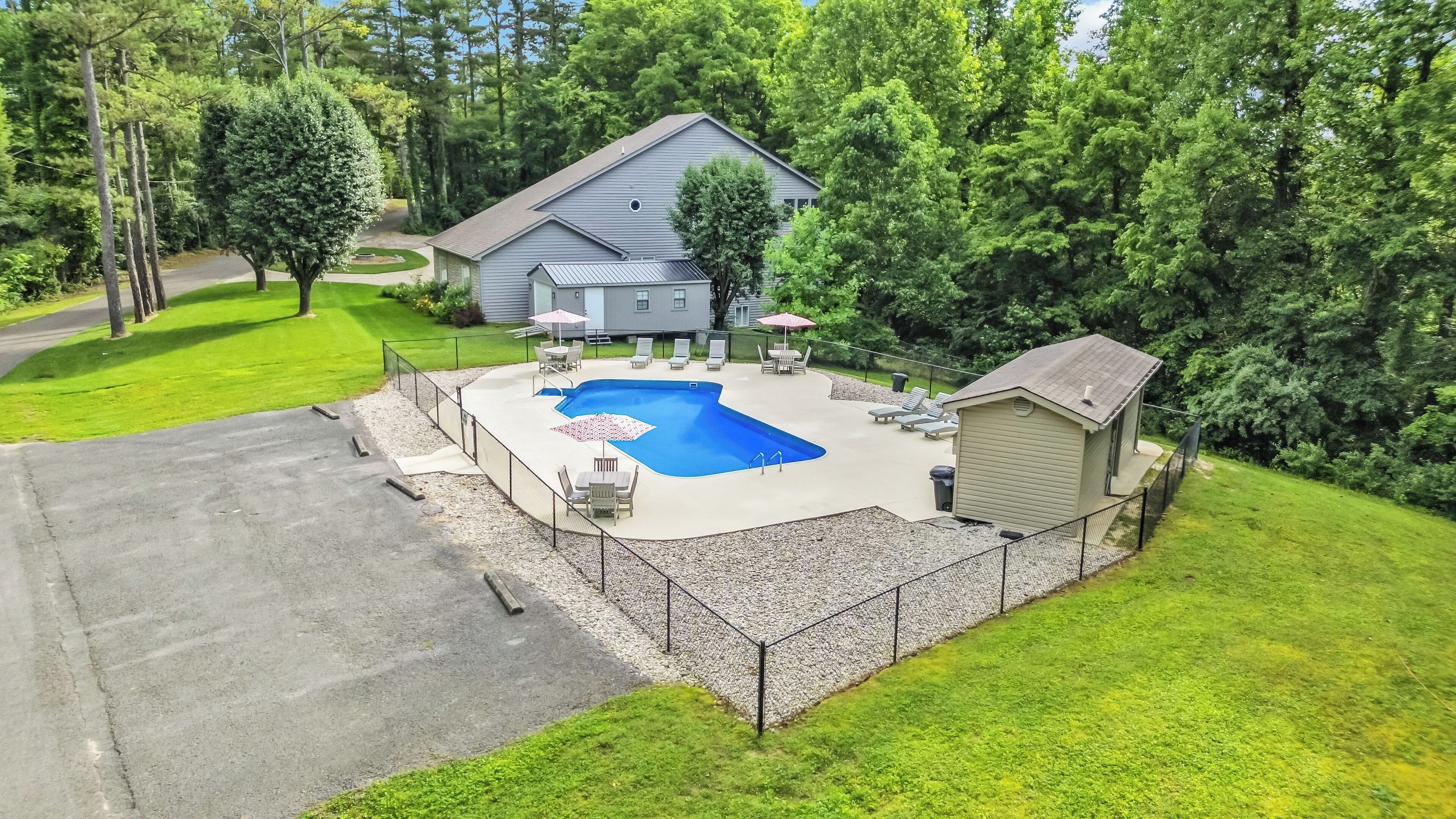 A residential property with a swimming pool, a covered patio, and a small shed.