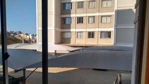 Blick aus einem Fenster auf einen Parkplatz mit einem Gebäude im Hintergrund.