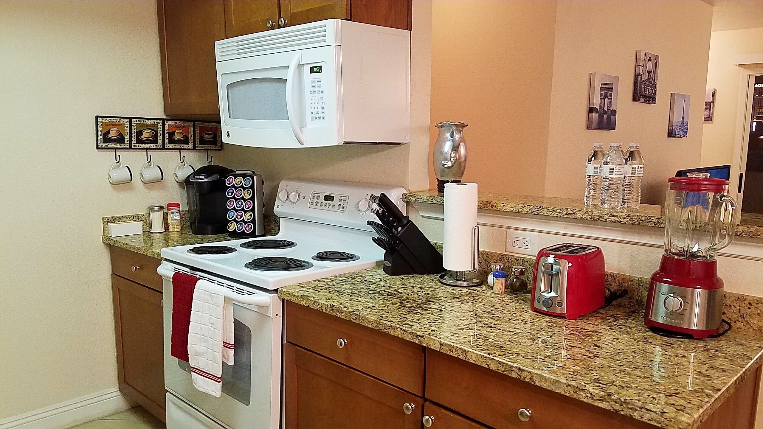 A kitchen with a stove, microwave, toaster, and blender.