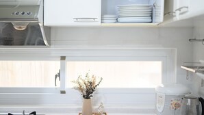 A kitchen with white cabinets, a stove, a coffee maker, and a window with a view. - 2 min to MRT, 4B2b Shopping/Restaurant District (Taipei)