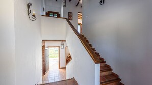 A staircase with wooden steps and a handrail, leading to a door with a glass panel. - Cantoblanco I Viñuela by Ruralidays (Málaga)