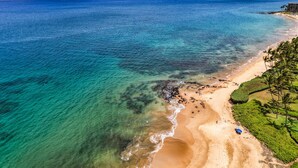 A coastal beach with clear waters, a sandy shore, and a mountain in the background. - Wailea Ekahi 34A Spacious Wailea 1BR w AC Pool Near Beach (Kihei)