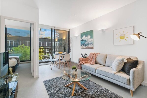 A modern living room with a sofa, coffee table, and artwork on the walls.