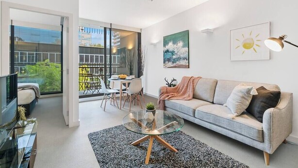 Ein modernes Wohnzimmer mit Sofa, Couchtisch und Kunstwerk an der Wand.