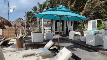 Playa privada, playa de arena blanca, camastros y sombrillas