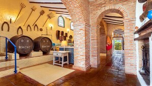 A rustic interior with brick arches, wooden barrels, and farm tools on the wall. - Sierra Tejeda  -  El Lagarillo Alcaucín by Ruralidays (Málaga)