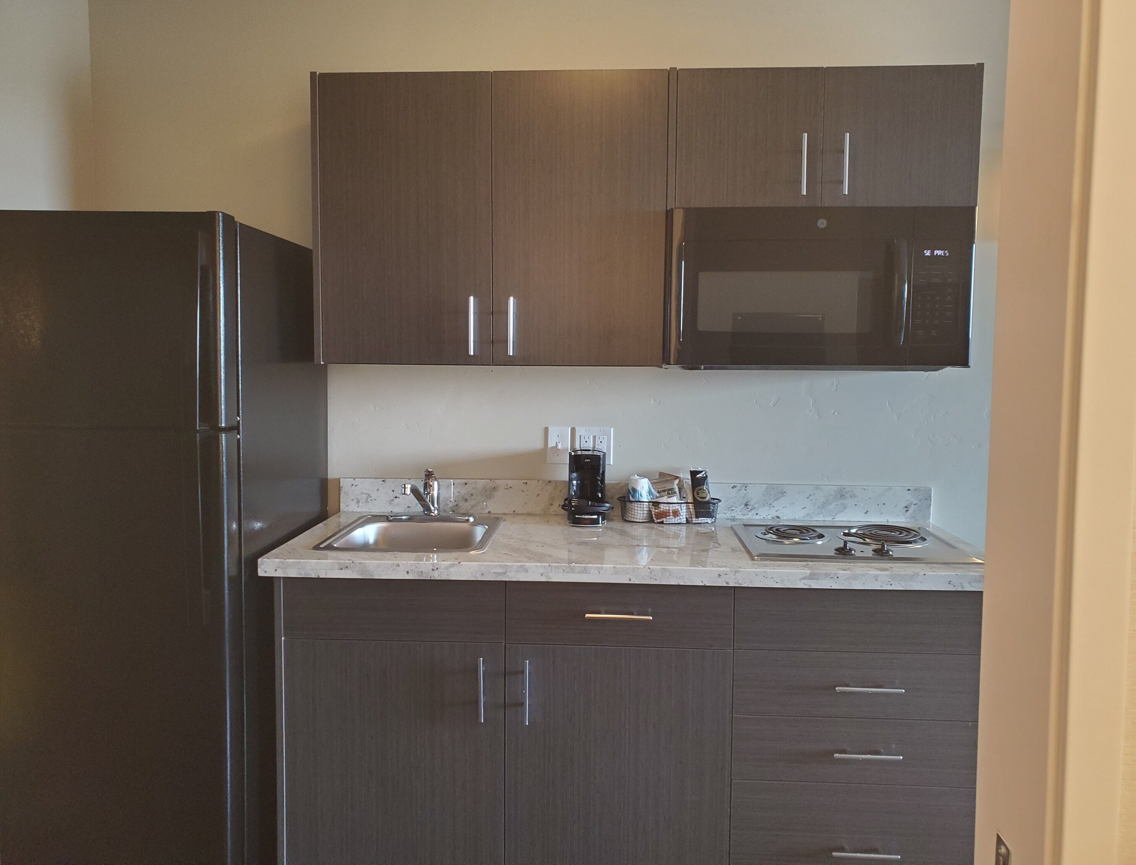 full-sized fridge, microwave, stovetop, coffee/tea maker