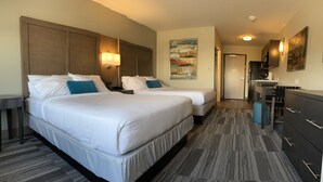 A hotel room with two beds, a desk, a chair, a dresser, and a painting on the wall. - Simple Suites Boise Airport (Boise)