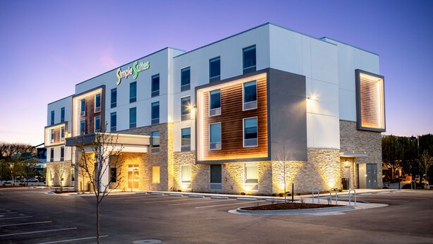 A modern hotel with a stone facade, multiple windows, and a well-lit entrance. - Simple Suites Boise Airport (Boise)