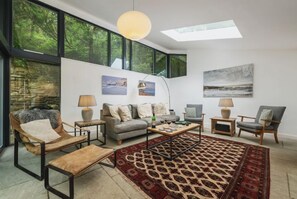 Un salon moderne avec un canapé, des fauteuils, une table basse et un tapis à motifs.
