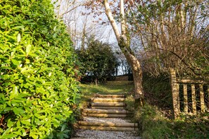 Stroll up the winding staircase to a serene natural oasis surrounded by lush greenery and trees.