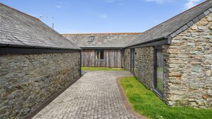 A stone building with a brick pathway leading to a wooden structure.