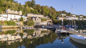 A marina with boats docked, surrounded by residential buildings and lush greenery. - This holiday home is situated right on the water’s edge within the Malpas Marina (Malpas)