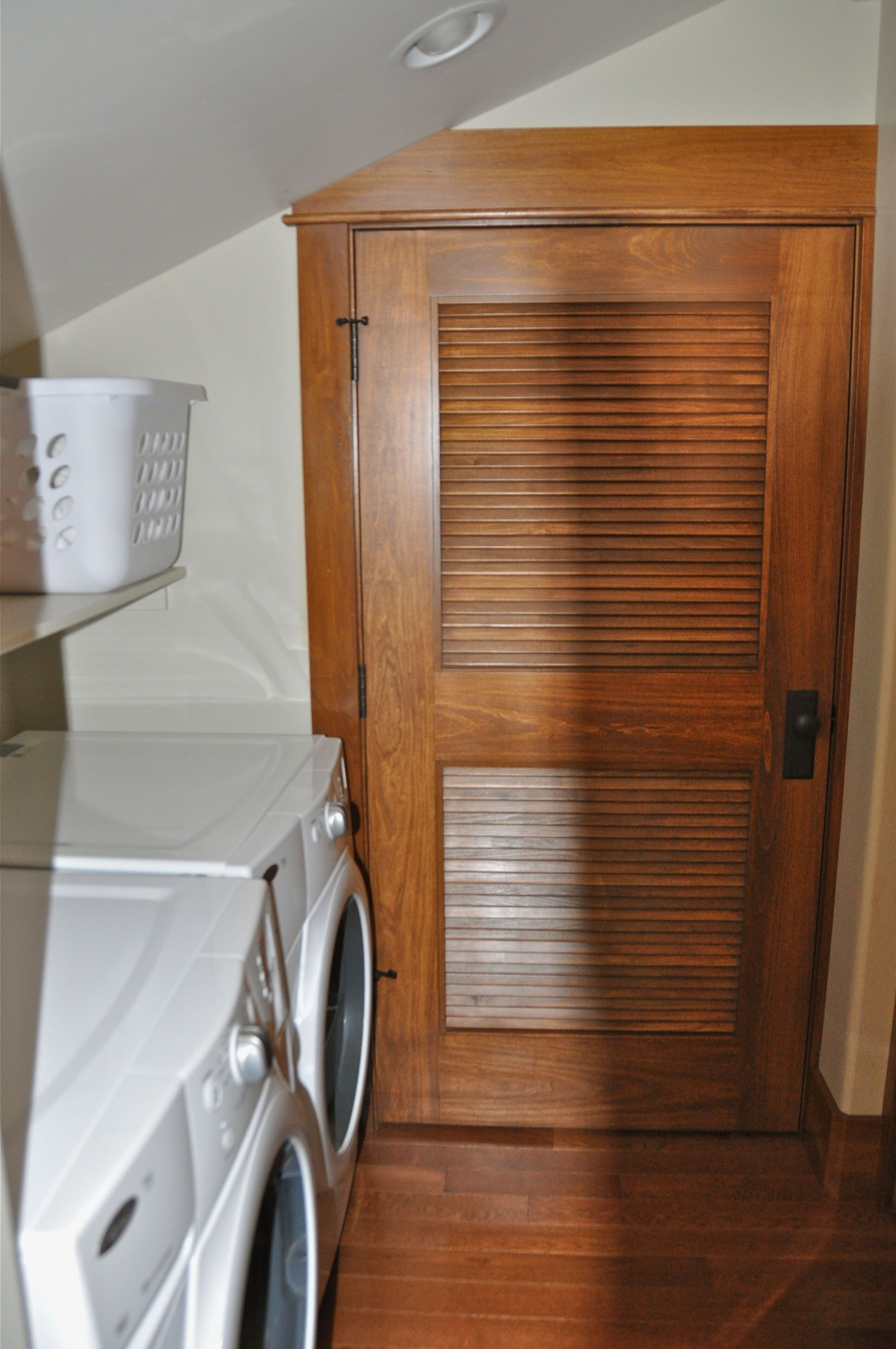 Une buanderie avec une porte en bois, un lave-linge et un sèche-linge.