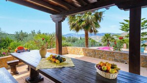 A wooden table with a placemat, a vase, and a fruit basket. - Las Lomas de San Rafael Periana by Ruralidays (Málaga)