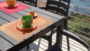 Ein Tisch mit Stühlen und Blick aufs Meer.