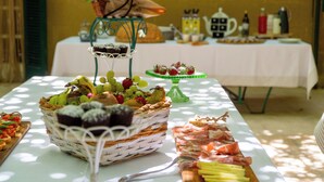 Een buffet met verschillende soorten eten, zoals fruit, gebak en vlees.