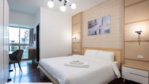 Un dormitorio con cama, mesitas de noche, una obra de arte en la pared y una ventana con vistas.