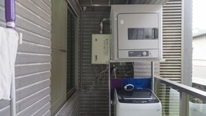Un cuarto de lavandería con lavadora, secadora y cuarto de servicios con calentador de agua y demás equipos.