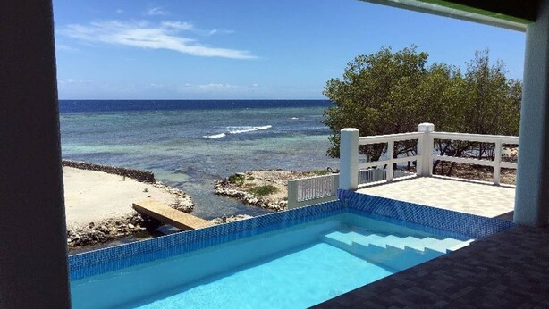 Une piscine avec vue sur l’océan et une plage.