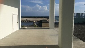 Un espace extérieur abrité offrant une vue sur la plage et l’océan.