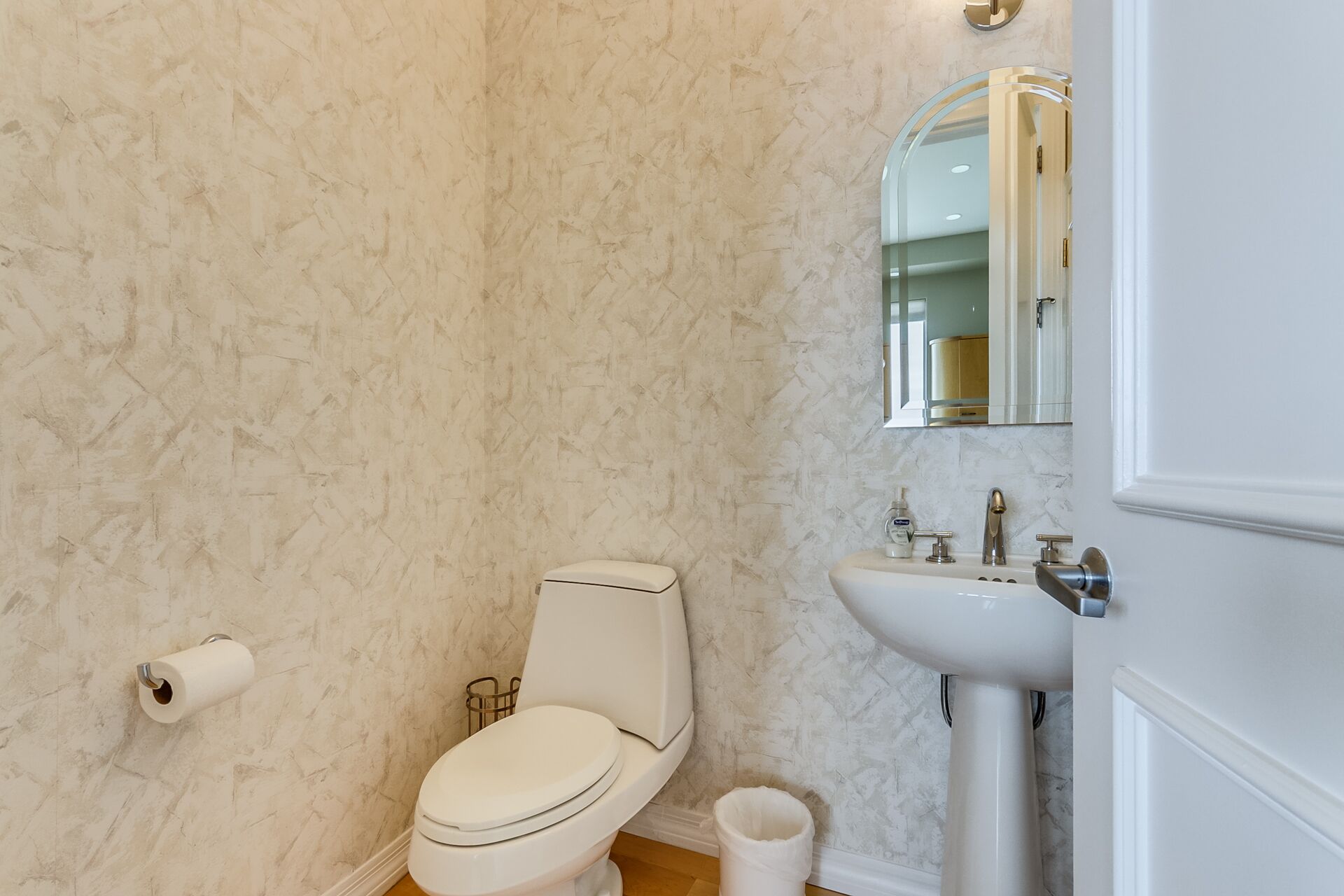 Une salle de bain avec des toilettes, un lavabo et un miroir.