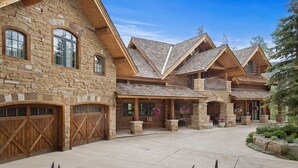 A large stone building with multiple wooden doors and a spacious courtyard. - HILLTOP HIDEAWAY- A Magical Mountain Ski Estate with Game Room, Hot Tub, and Vie (Telluride)