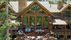 A log cabin with a large deck, outdoor seating area, and multiple windows. - HILLTOP HIDEAWAY- A Magical Mountain Ski Estate with Game Room, Hot Tub, and Vie (Telluride)