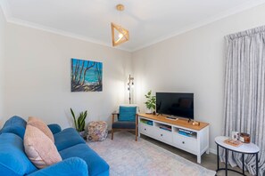 Relax in this inviting living space with a sofa, side table, and floor lamp.