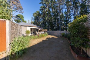 Enjoy a serene outdoor space with a well-maintained lawn and trees, perfect for dining or relaxation.