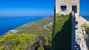 A stone structure with a small window, surrounded by greenery and overlooking a coastal landscape. - Apartment in Ždrelac with Seaview, Balcony, Air condition, WIFI (4561-1) (Ždrelac)