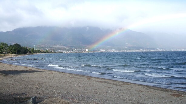 A beach with a mountain in the background and a rainbow in the sky. - Youth Hostel WANIHIMA~Lakeside BIWA (Otsu)