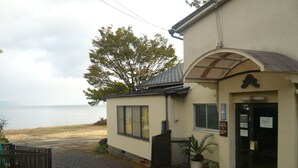 A building with a beach view, a small porch, and a sign indicating it is a coffee shop. - Youth Hostel WANIHIMA~Lakeside BIWA (Otsu)