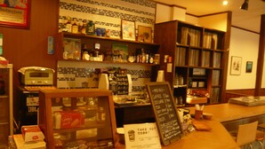 A bar area with a coffee machine, shelves with bottles, and a menu board. - Youth Hostel WANIHIMA~Lakeside BIWA (Otsu)