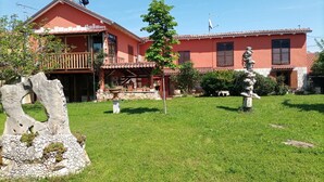 A two-story house with a red facade, a balcony, and a stone sculpture in the yard. - Apartment in Umag with Air condition, WIFI (4222-1) (Umag)