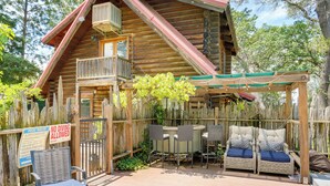A log cabin with a balcony, outdoor seating, and a 'No Diving Allowed' sign. - Log Cabin Retreat with Pool and Vineyard Views (Cottonwood)