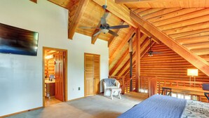 A bedroom with a bed, a ceiling fan, a chair, and a wooden ceiling. - Log Cabin Retreat with Pool and Vineyard Views (Cottonwood)